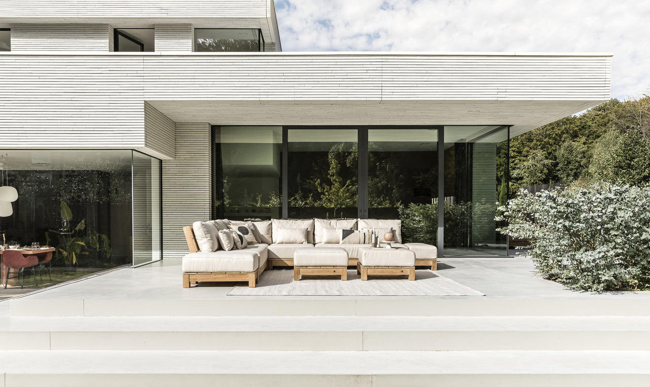 Lounche tuinset tegen een modern wit huis