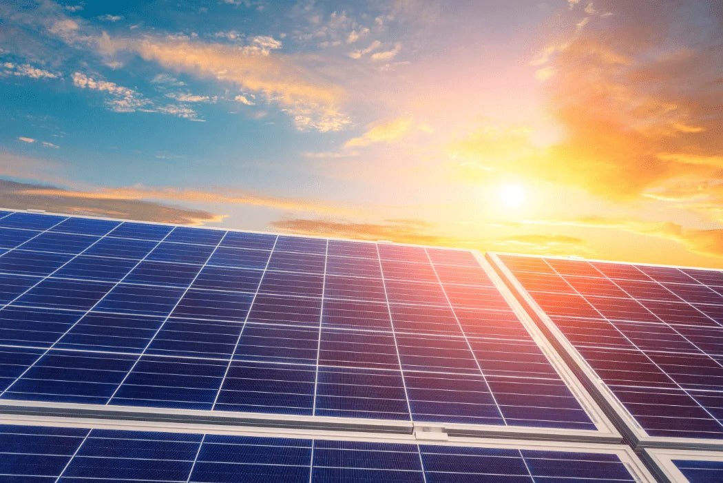 Zonnepanelen tegen een levendige zonsopgang met kleurrijke wolken.