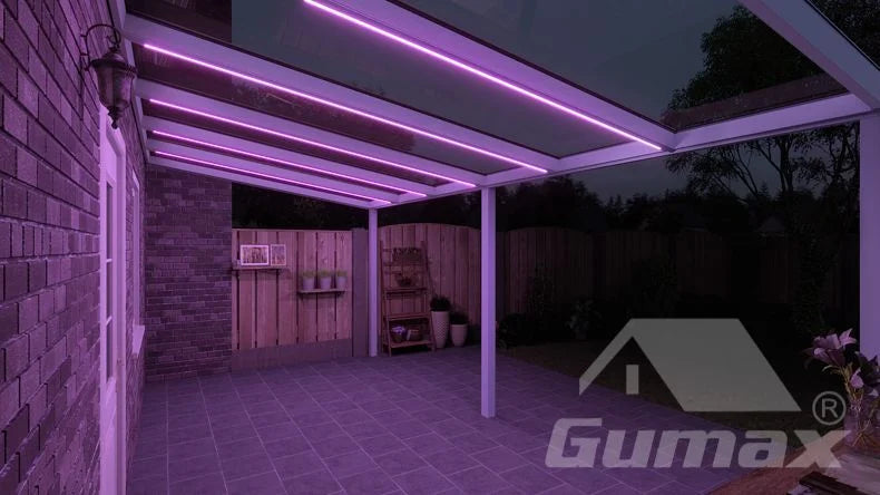 Een avondzicht op een terrasoverkapping met antracietkleurige lamellen en geïntegreerde LED-verlichting.