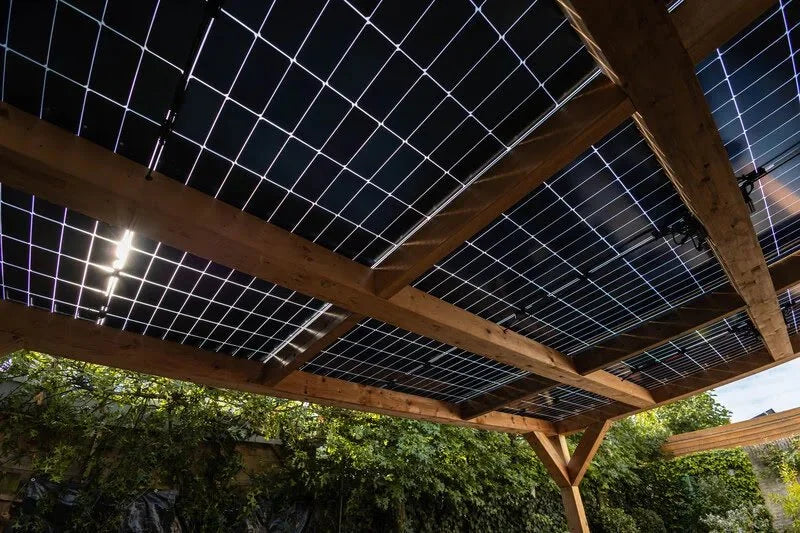 Onderaanzicht van een houten veranda met zonnepanelen.